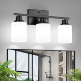 Ascher 3-light vanity fixture in black finish over bathroom mirror for clear task lighting.