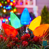 Brightown C9 LED string lights on green wire illuminate outdoor rooflines for festive decor.