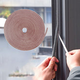 Bruiefpap weather strip adhesive roll in brown seals air gaps to reduce drafts.