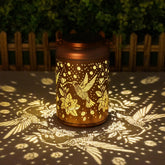 Cawalap hummingbird solar lantern hanging on a tree for warm garden ambiance.