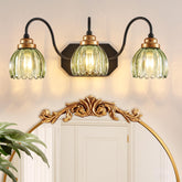 CmnVmn vintage vanity light with green shades provides soft ambient bathroom illumination.