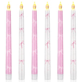 Conelist Coquette pink bow flameless taper candle closeup with warm LED glow for romantic ambiance.