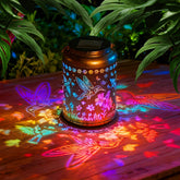 Dellicasi solar hummingbird lantern garden decor hung on a tree at dusk for ambiance.