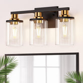 DORESshop three-light black-gold vanity light with clear glass shade enhances bathroom ambience.