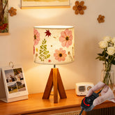 Floresita tripod lamp with wooden base showcases dried flowers for a cozy bedside glow
