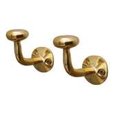 HANDLUX unlacquered brass wall hook holding coats with vintage charm