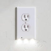Hello Light wall plate night light emits a gentle ambient glow from a duplex outlet.