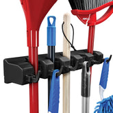 HOME IT Mop and Broom Holder on wall with five slots and six hooks for organized storage.