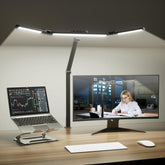 Honeywell wide desk lamp with clamp illuminating a large workspace for dual monitors