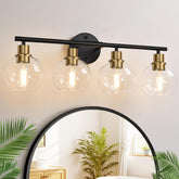 Indoi 4-light vanity fixture in black and gold with clear globe shades above the mirror.