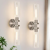Indoi wall sconces with brushed-nickel finish and clear-glass shades illuminate a bathroom mirror