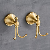 KWQKEM antique brass towel hook with double hooks for towels and robes in bathroom.
