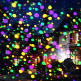 Lingvee Mardi Gras projector light on a stake illuminating a festive outdoor space.