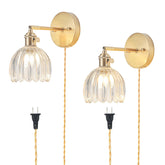 LINSEEDS plug-in sconce with tulip glass shade for warm bedroom ambiance.