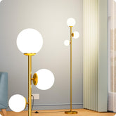 Nukanu floor lamp with three frosted glass shades in a gold finish for warm ambient lighting