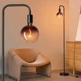 ONEWISH floor lamp with globe bulb casts warm ambient light beside a sofa
