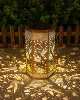 Opjoy hummingbird solar lantern glows in the garden, adding warm ambiance