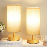 PartageiZ small table lamp in gold on a nightstand with warm ambient light