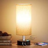 PartageiZ small touch bedside lamp providing warm illumination on a nightstand.