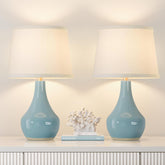 Seealle sky blue table lamp on nightstand emits soft, inviting light.