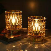 SJIE battery-operated lamp with glass base glowing softly on a nightstand.