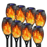 Swingers solar flame torch lights illuminate walkways with a warm glow.