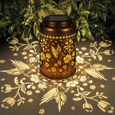 Tepaken solar lantern with hummingbird pattern hanging design provides warm garden ambiance.