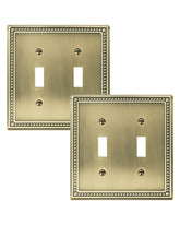 Treewell Pearls double-toggle wall plate in antique brass enhances traditional room cohesion