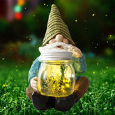 Vcdsoy Solar Firefly Jar Gnome glowing at night with firefly LED bulbs, perfect for garden magic.