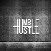 YIKBIK Hustle sign on the wall with white glow enhances modern room decor.