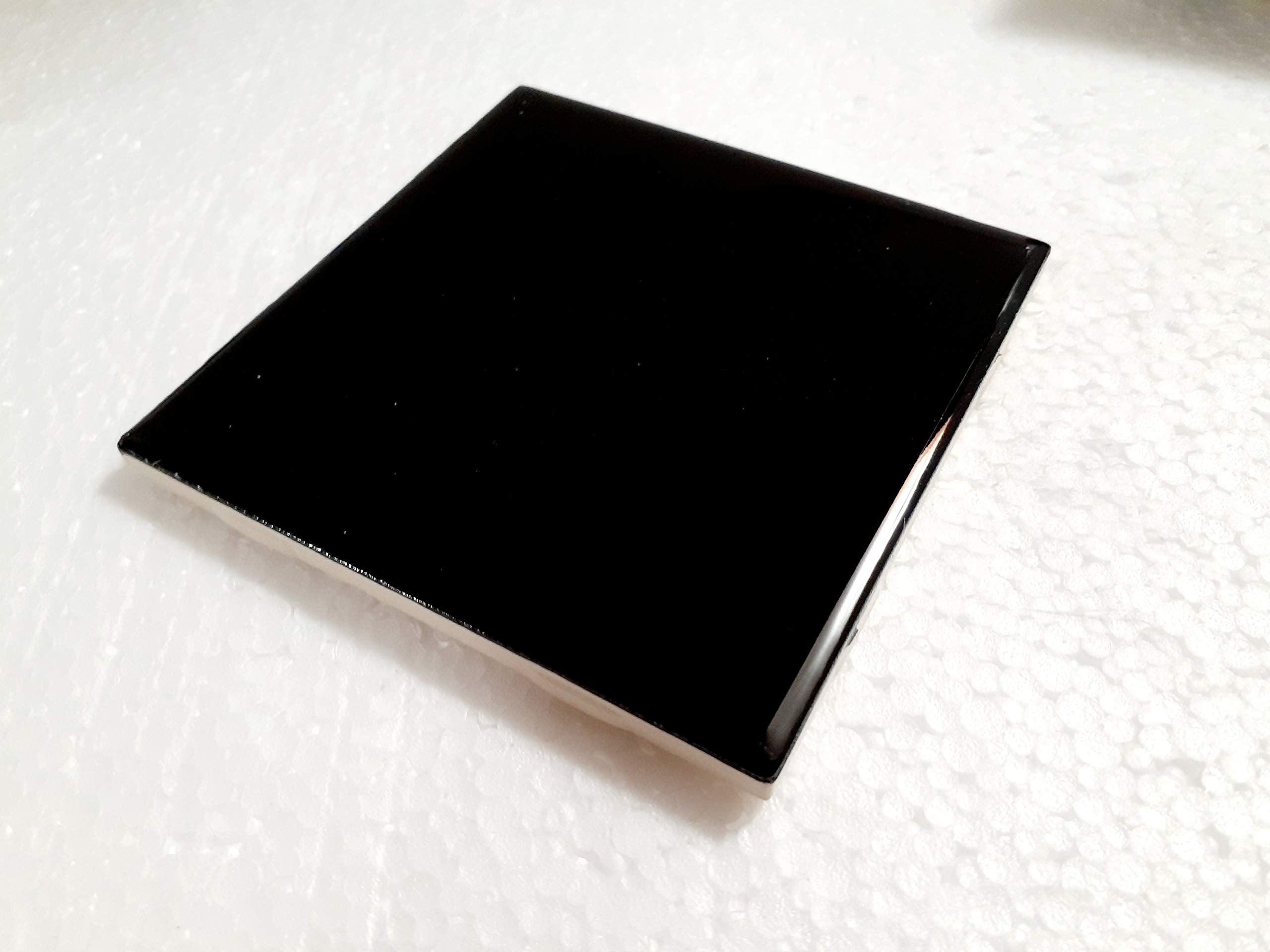 Black gloss ceramic tile by American Olean used as kitchen backsplash.