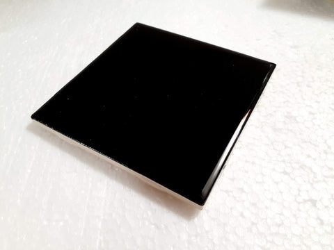 Black gloss ceramic tile by American Olean used as kitchen backsplash.