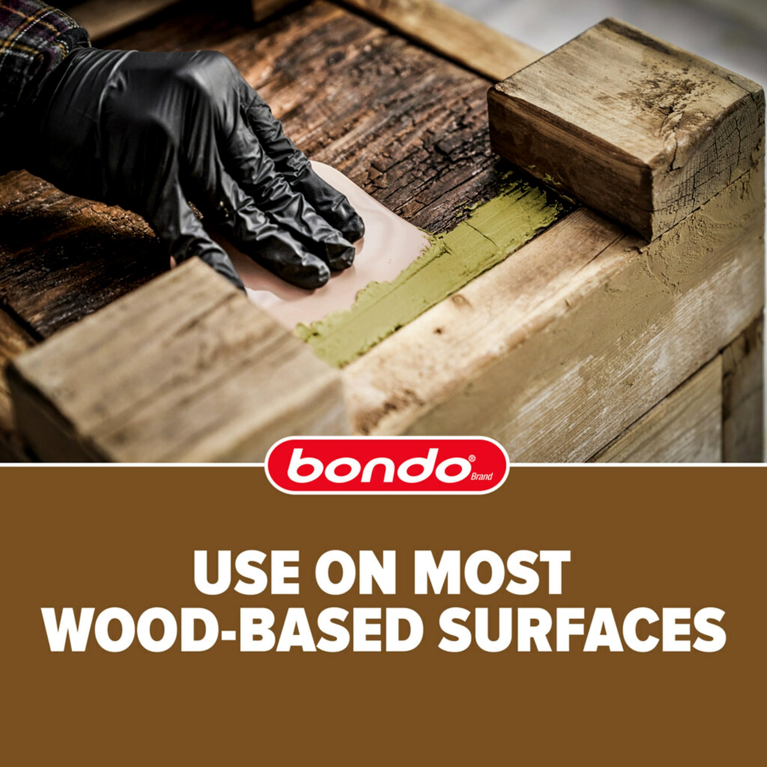 Spread a patch of Bondo Wood Filler on rotted wood to prepare for restoration.
