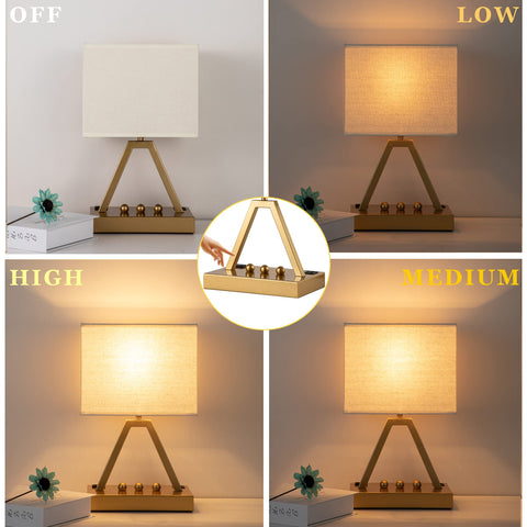 Briever gold lamp on a desk with built-in phone stand for charging.