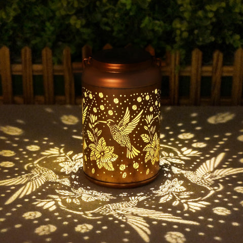 Cawalap hummingbird solar lantern hanging on a tree for warm garden ambiance.