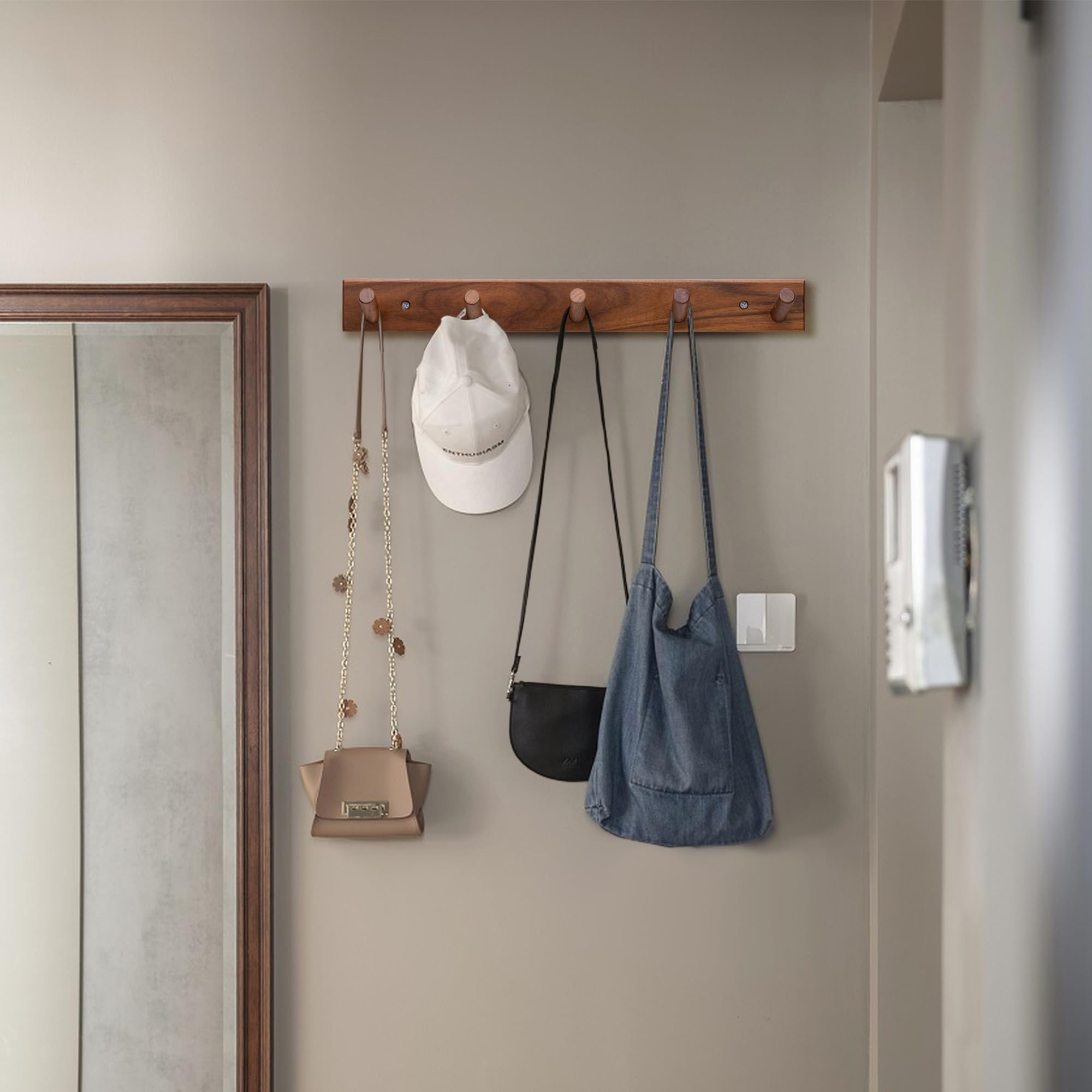 Chiumay teak wall hooks in entryway organize coats and bags.