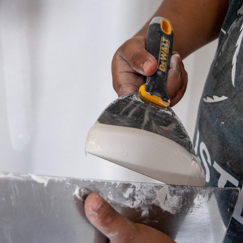 DEWALT putty knife hammer end helps reset nails and protect the blade.