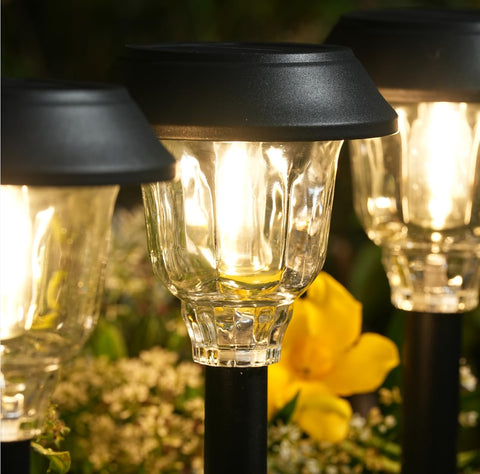 Doeslag solar-pathway-light-glass-shade casts warm ambient patterns along walkways.