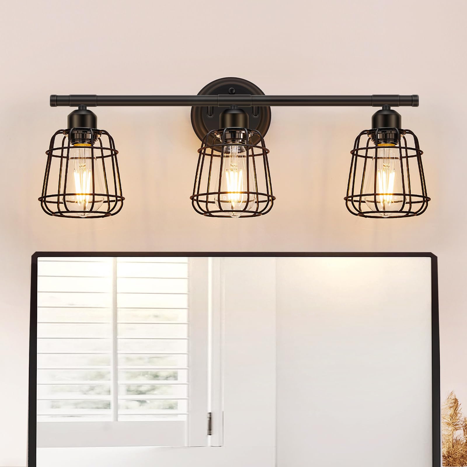 Elibbren 3-light vanity light in matte black cage over a bathroom mirror.