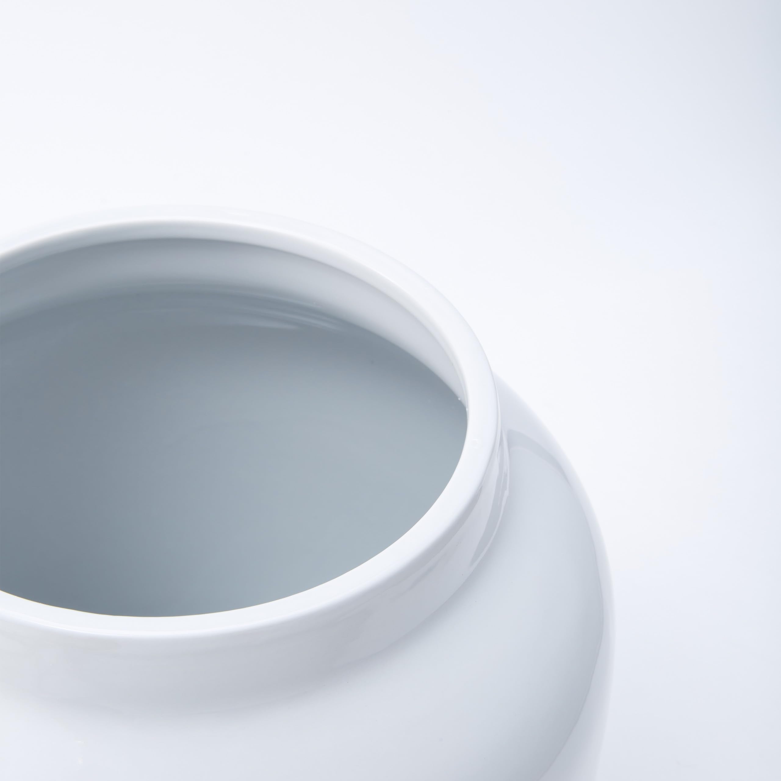 Compact dispenser on a kitchen counter beside glassware.