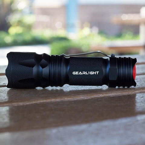 GearLight M3 mini flashlight casting a wide beam in a dark room for full visibility.