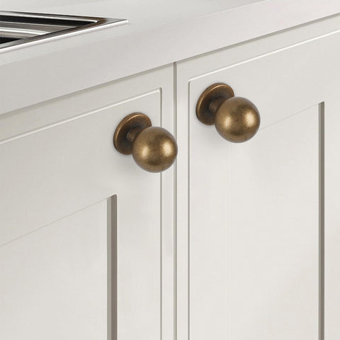 GIYURO antique brass cabinet knobs on a cabinet door