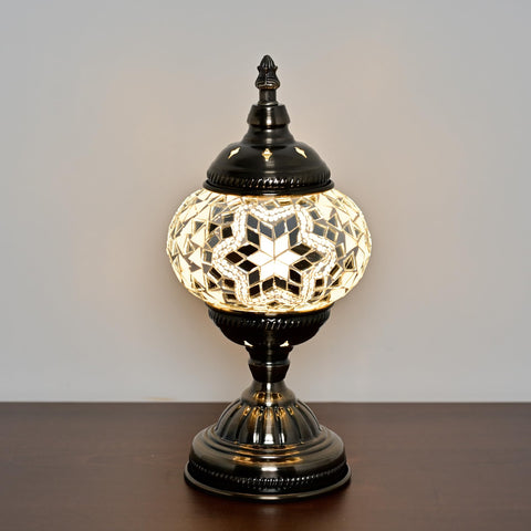GOGERS lamp lit with warm glow in a cozy bedroom setting