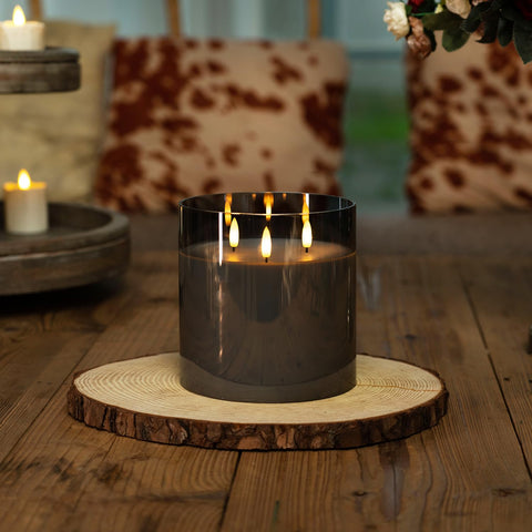 Homemory three-wick glow candle emitting balanced light on grey glass