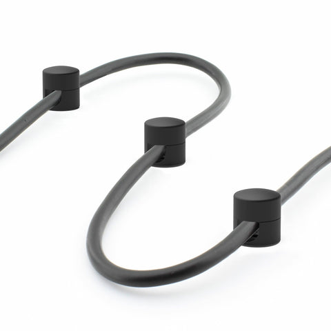 Cables stay aligned under a monitor with ICONIT anchors.