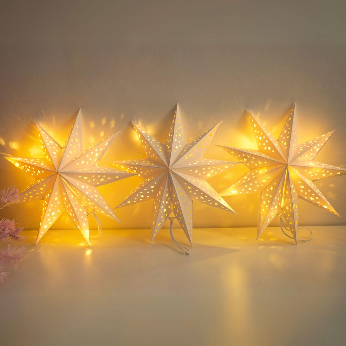 JINKEYULV paper star lanterns 3-pack illuminate windows with a warm, festive glow