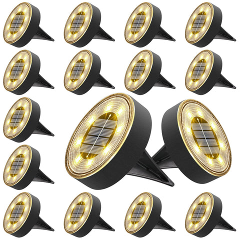 Joomer solar ground light with 8-LED disc illuminating a garden path with warm white glow.