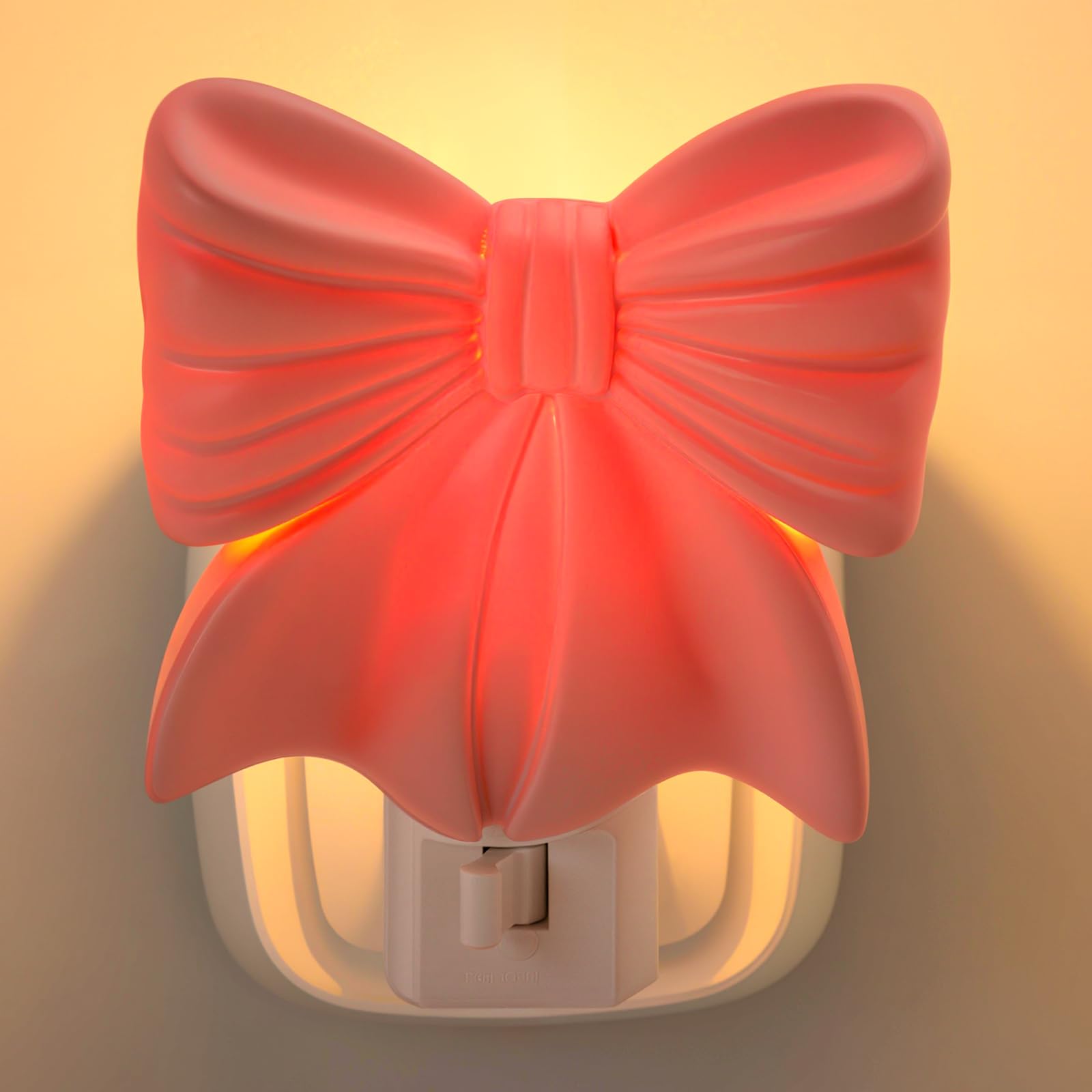 Kittmip pink bow night light plugged in to create cozy bedroom ambience.
