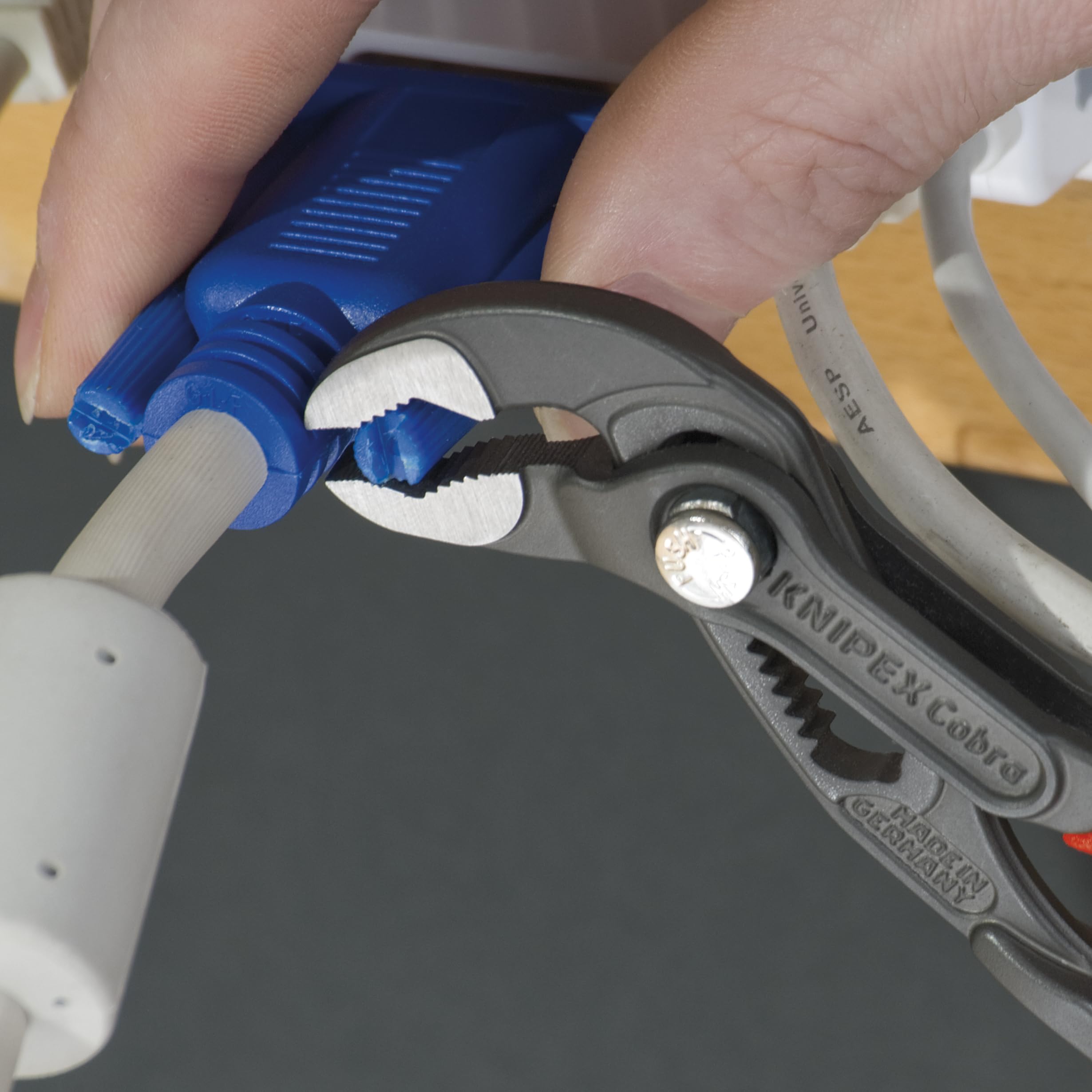 KNIPEX Cobra Pliers in use gripping pipes and nuts with self-locking action