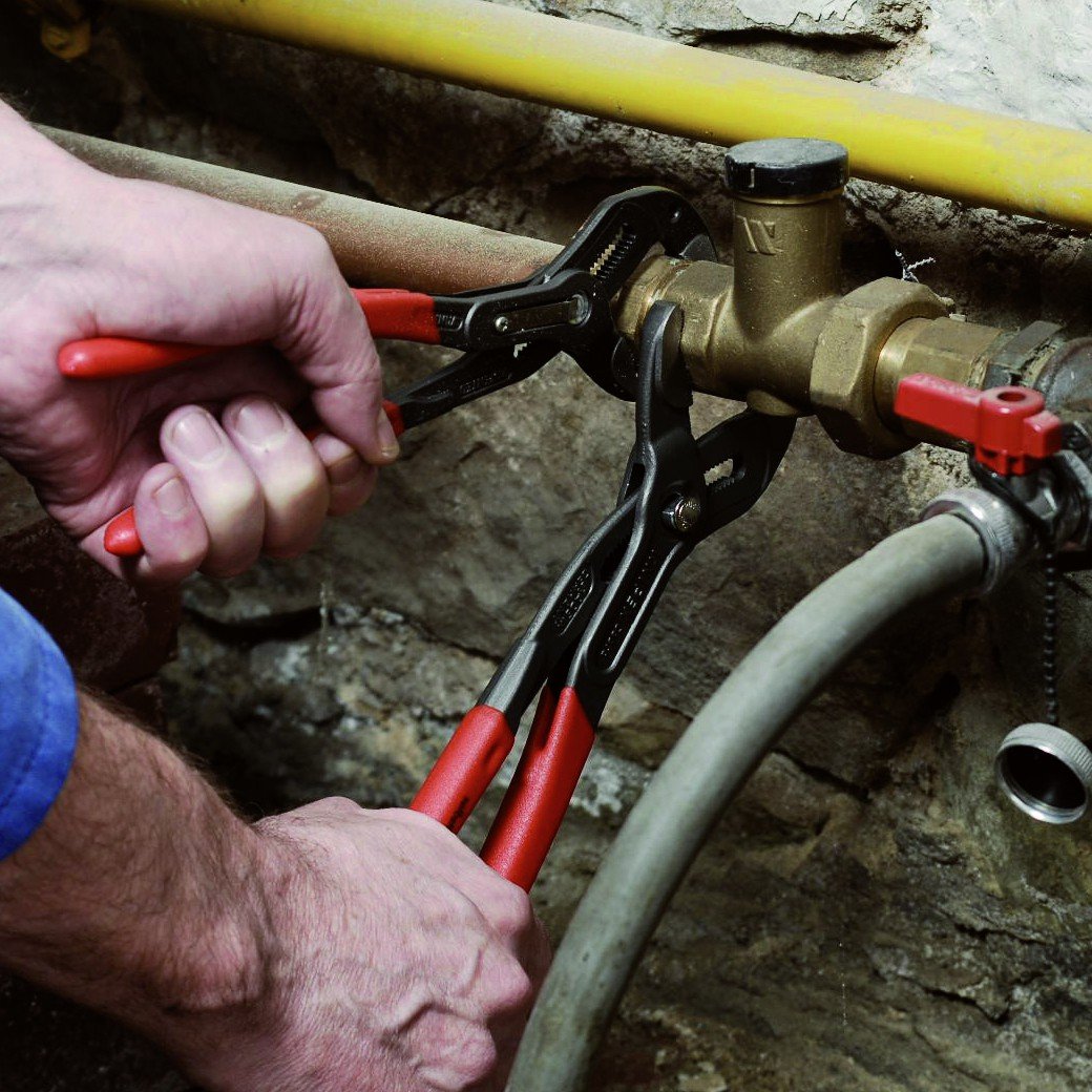 KNIPEX Cobra pliers gripping nuts and pipes with durable construction.